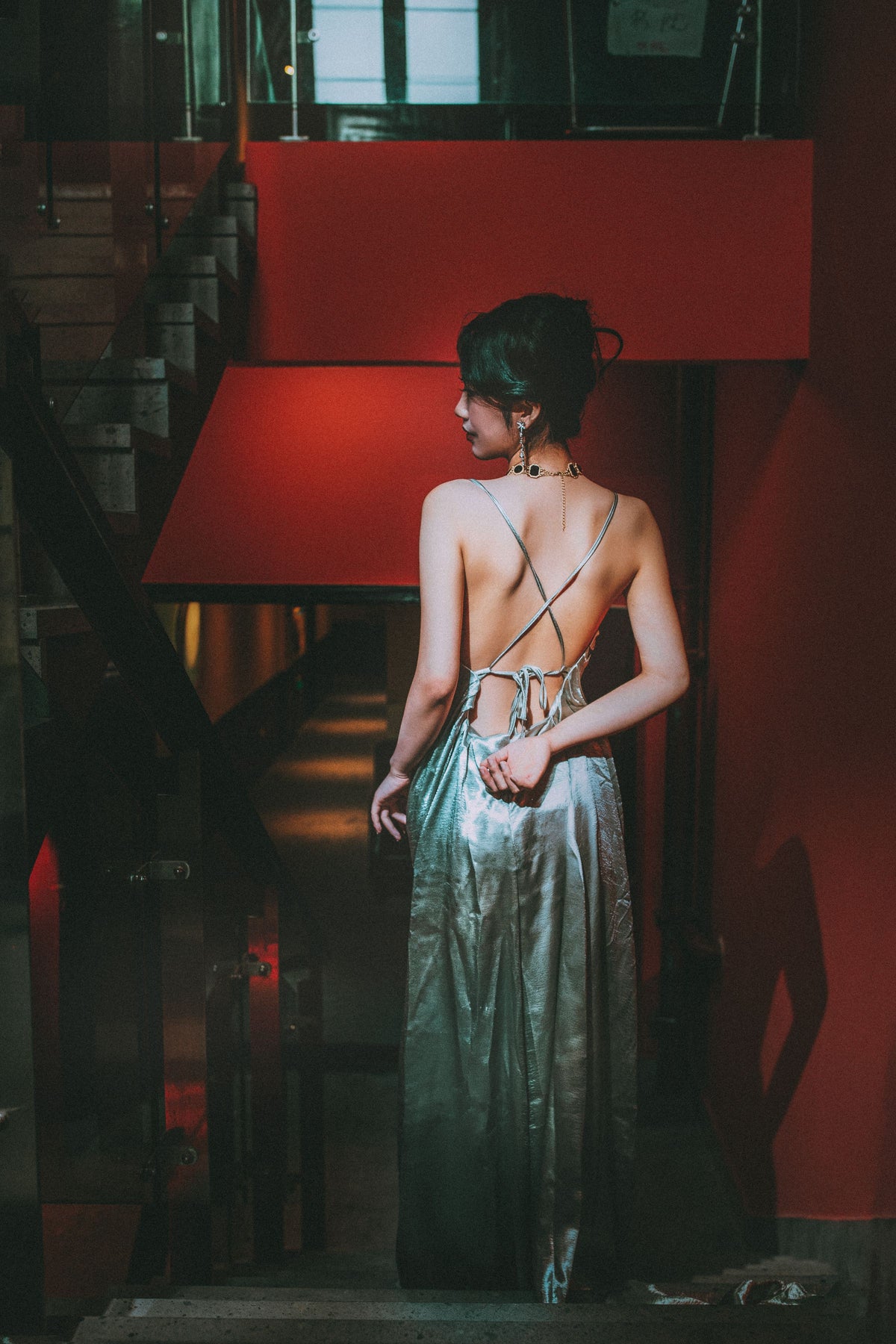 Woman in a red evening gown standing in a refined interior
