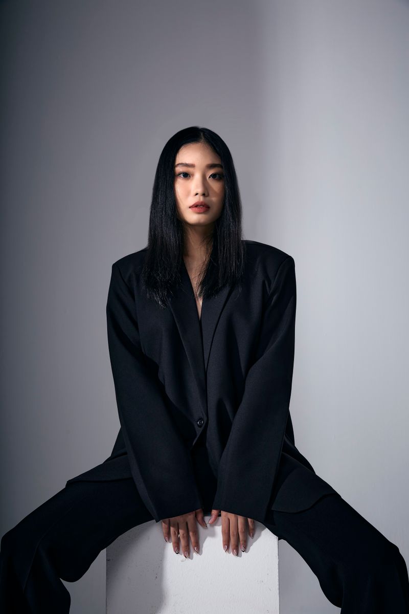Woman posing in a sophisticated black suit
