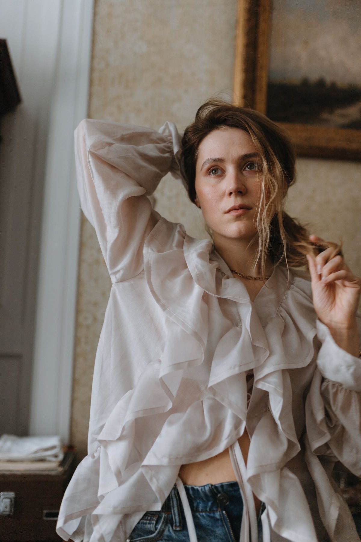 Woman wearing a white statement blouse in a classic interior